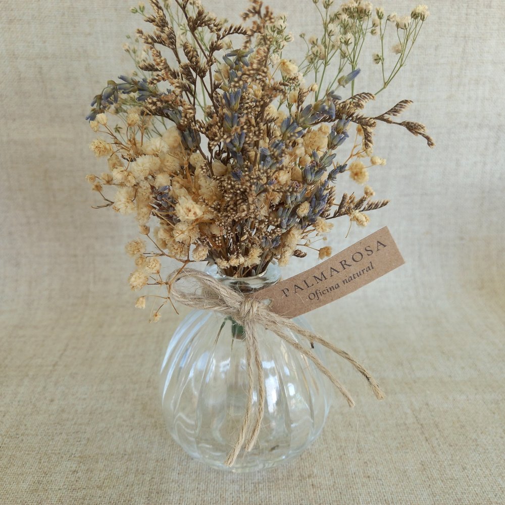 Arranjo delicado de flores desidratadas, cuidadosamente montado à mão e acomodado em um vaso de vidro com amarração em sisal. Com lavandas, sempre-vivas e outras espécies secas