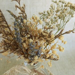 Arranjo delicado de flores desidratadas, cuidadosamente montado à mão e acomodado em um vaso de vidro com amarração em sisal. Com lavandas, sempre-vivas e outras espécies secas