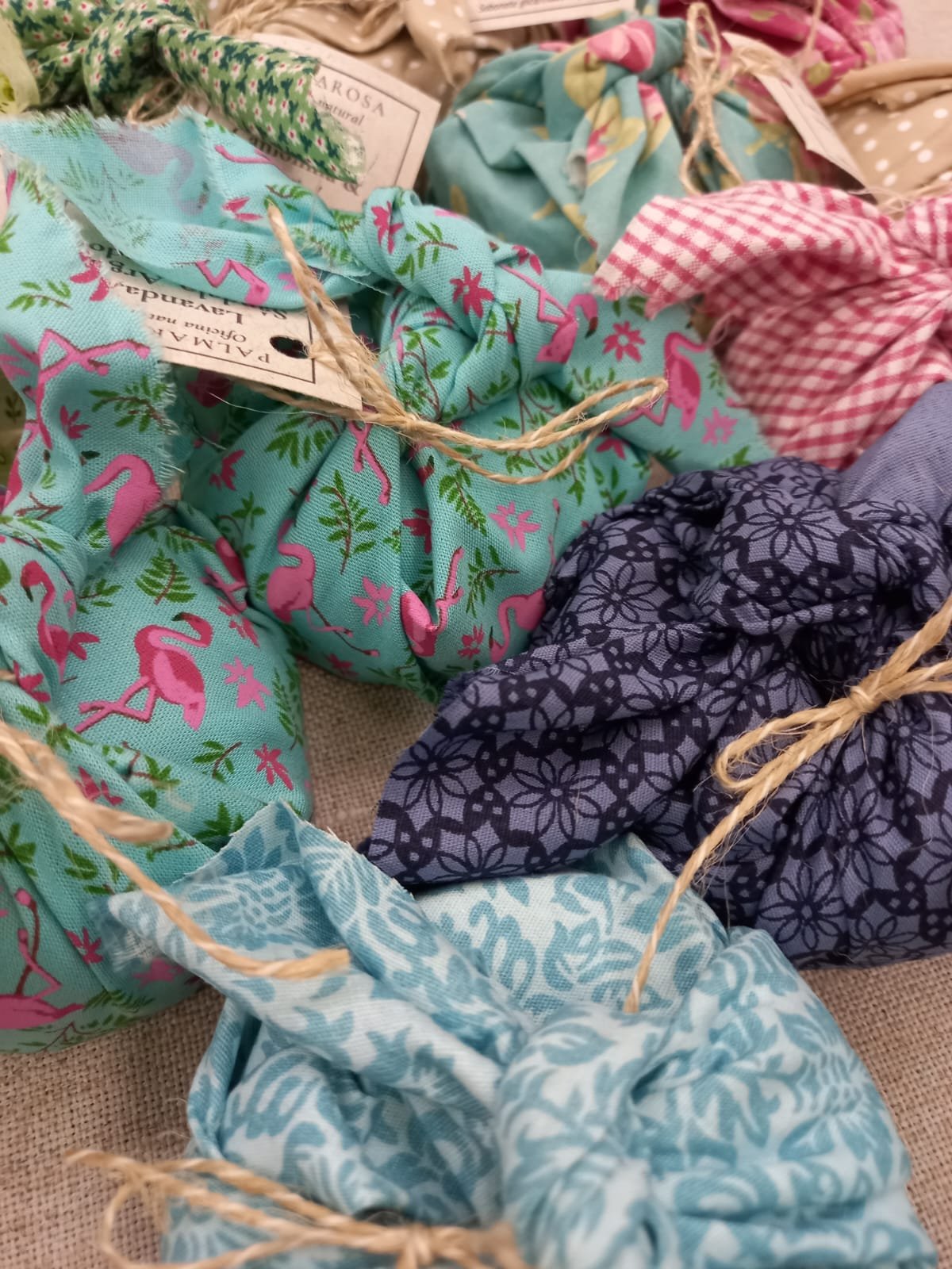 Sabonetes artesanais Palmarosa embalados em tecido 100% algodão com técnica japonesa furoshiki, em estampas coloridas e acabamento manual.